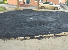 Рабочие заасфальтировали газон у жилого дома в Омске