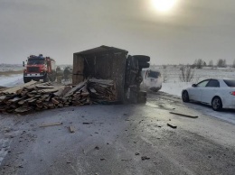 На алтайской трассе грузовик перевернулся, рассыпал дрова и загорелся